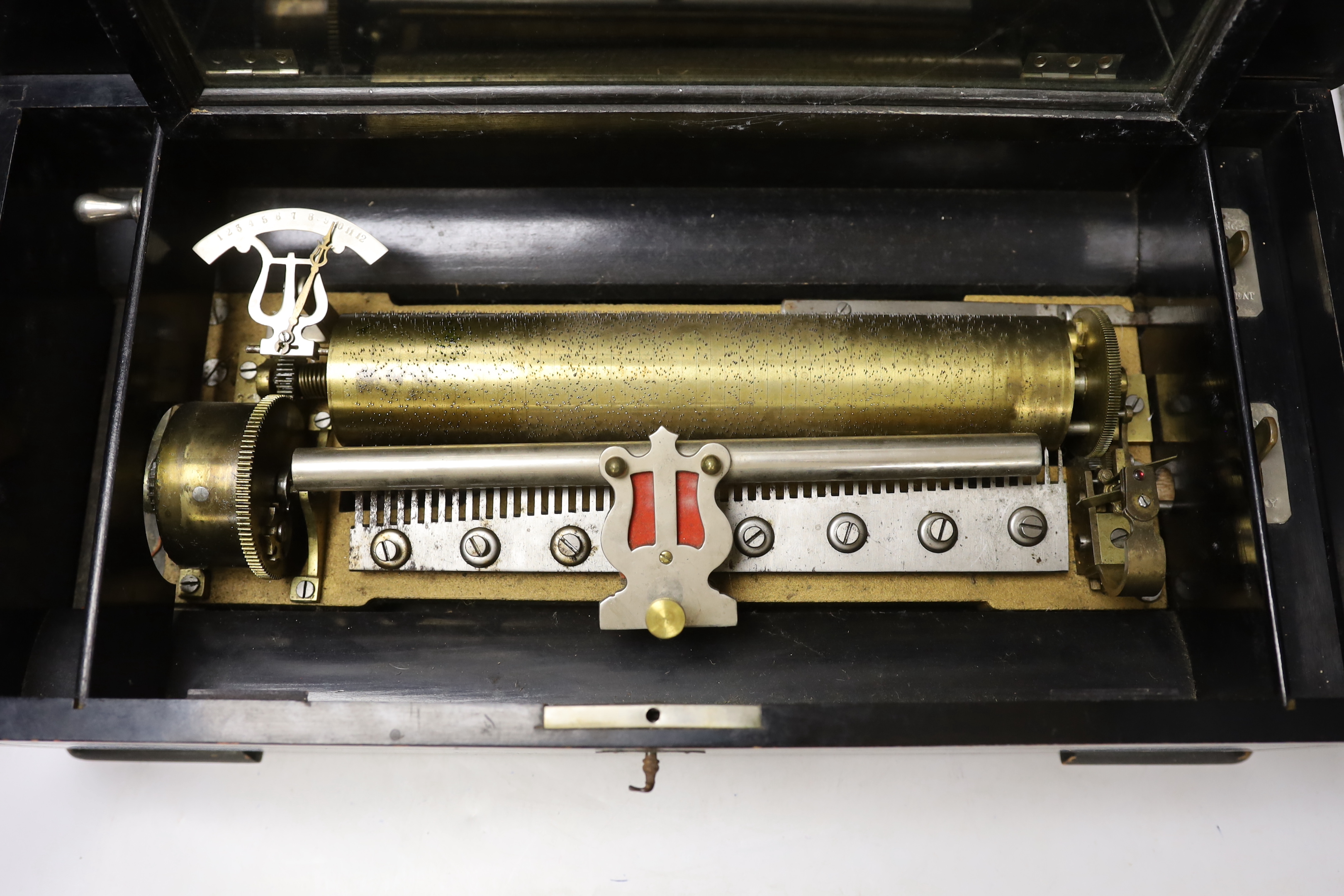 A late 19th century Swiss inlaid rosewood cased musical box, single cylinder with a 52 note comb playing twelve airs, tune indicator below glass dust cover, with tune list on underside of lid, 51 x 16 x 25cm